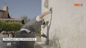 Personne appliquant du mortier sur un mur, Turone Façades.
