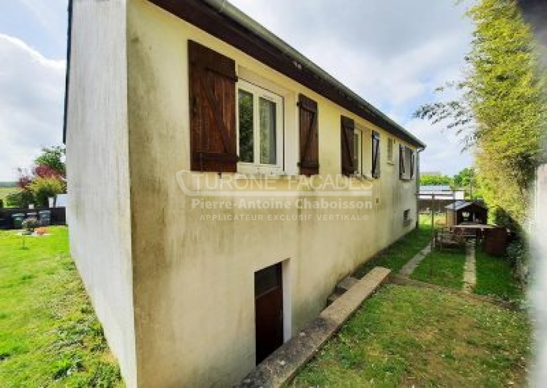 Turone Maison blanche avec volets marron.